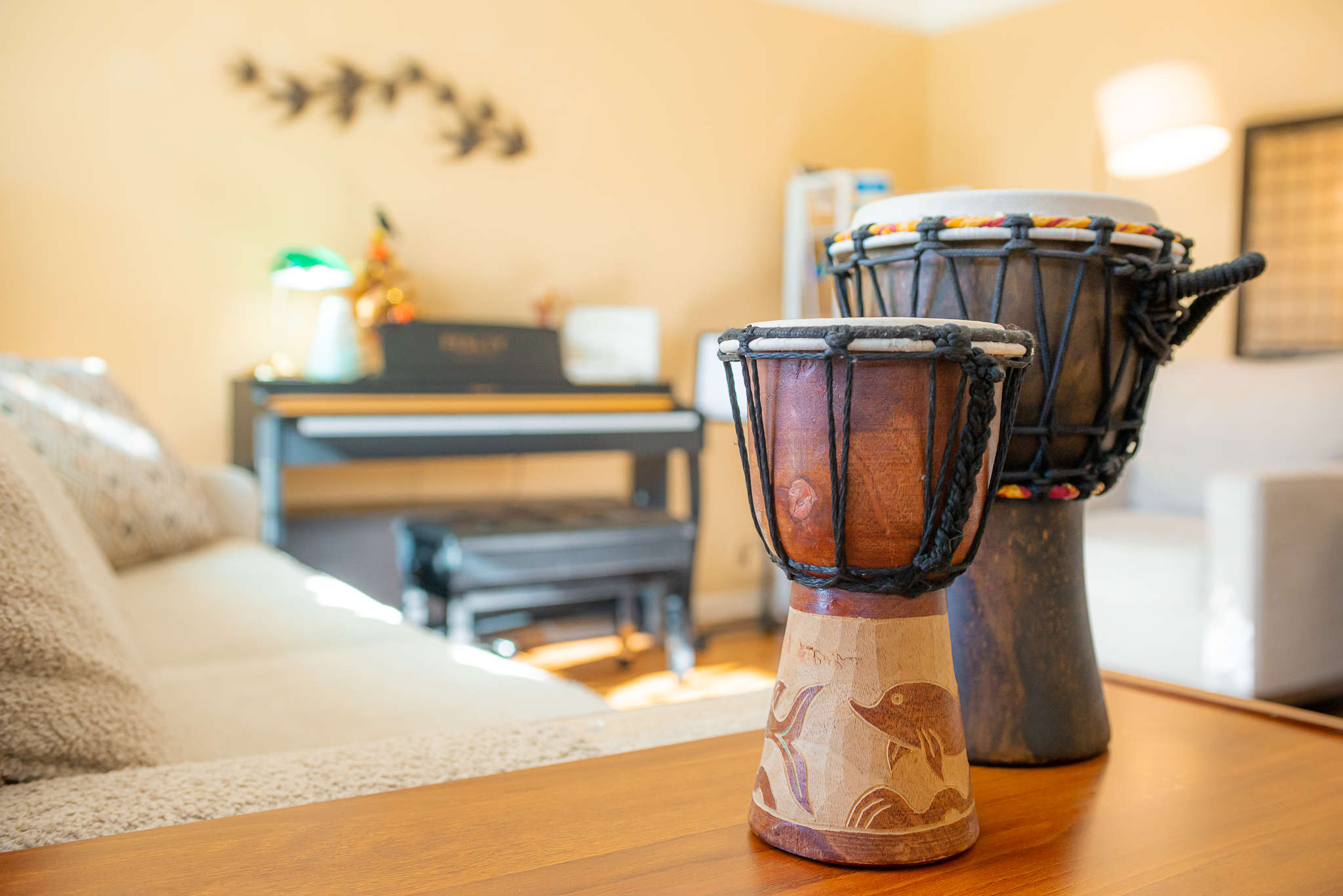 small drums in living room with piano in the background